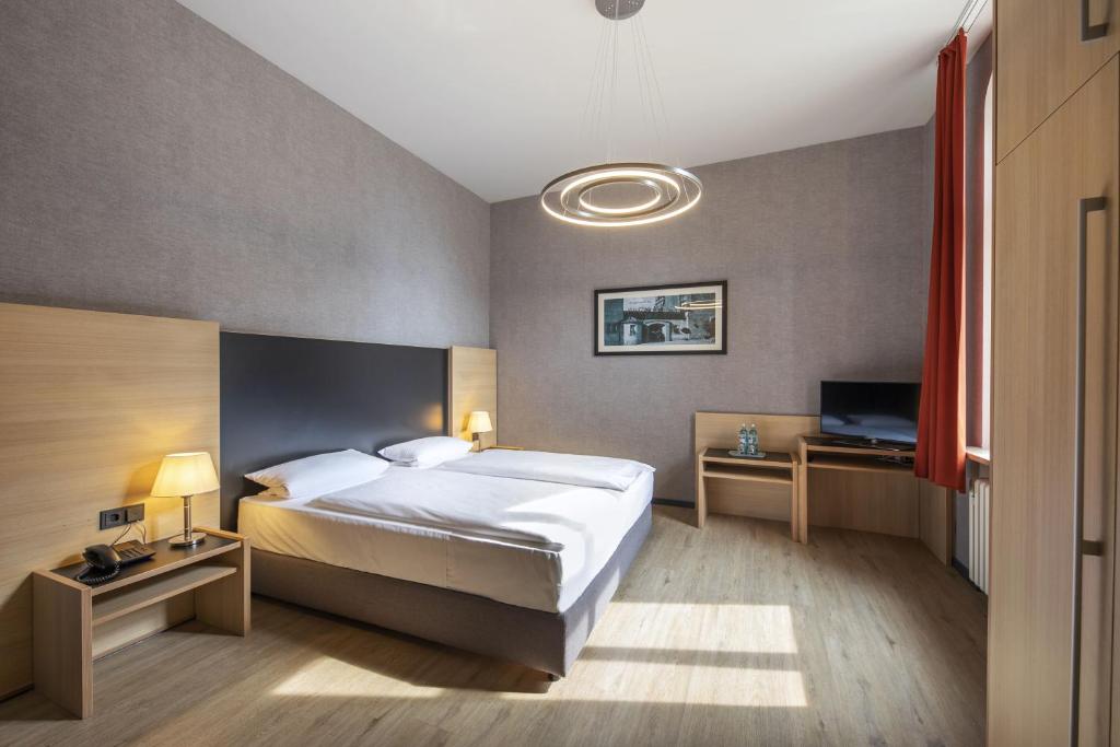 Postel nebo postele na pokoji v ubytování Roomingtons Hotel Franziskushöhe Lohr