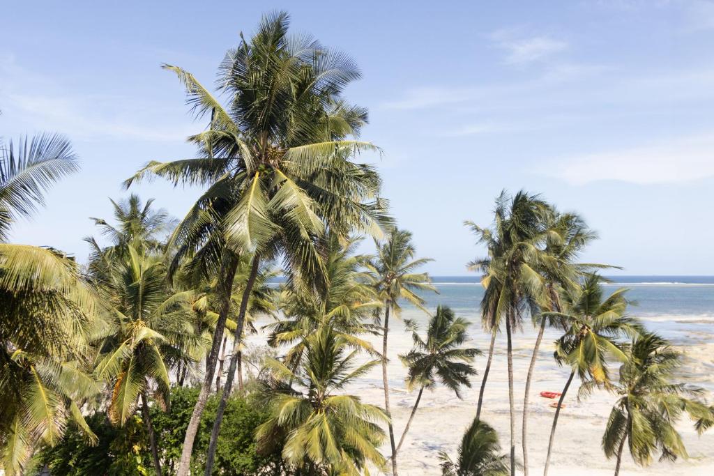 a group of palm trees on a beach at Beachfront Luxurious Apartment in Mombasa
