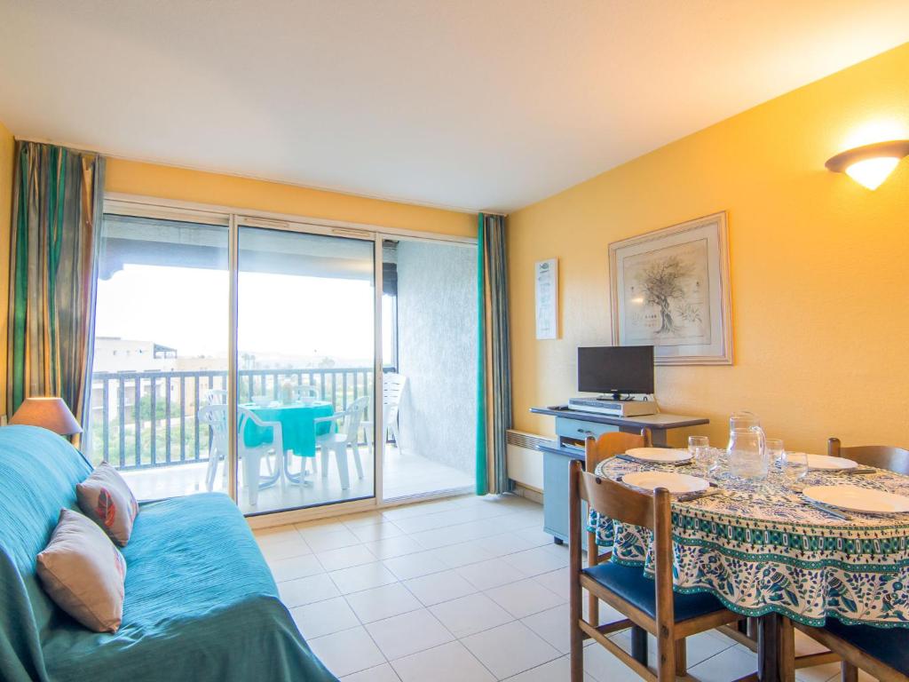 Il comprend un salon avec une table à manger et un balcon. dans l'établissement Apartment Les Marines-3 by Interhome, à La Foux
