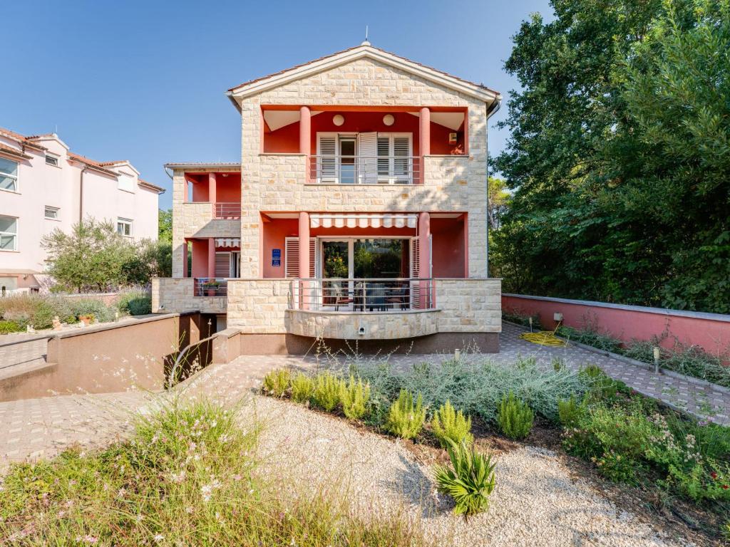 a red house with a balcony in the yard at Holiday Home Morski dragulj by Interhome in Vodice