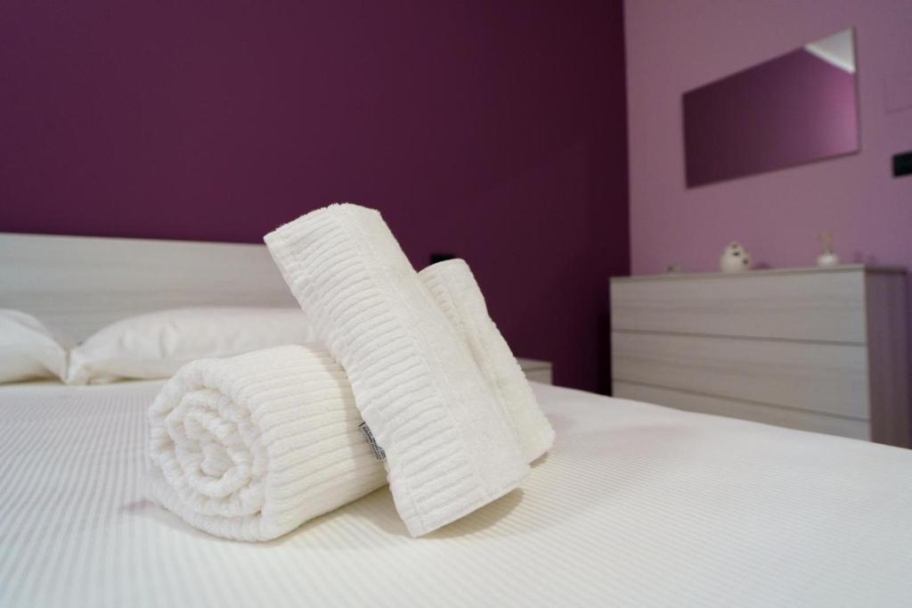 two rolls of white towels sitting on a bed at Maccuro Luxury Apartment in Vibo Valentia Marina