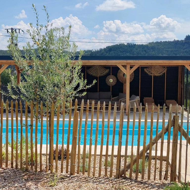 a fence in front of a house with a pool at Gîte, aux portes du Morvan in Voudenay-lʼEglise
