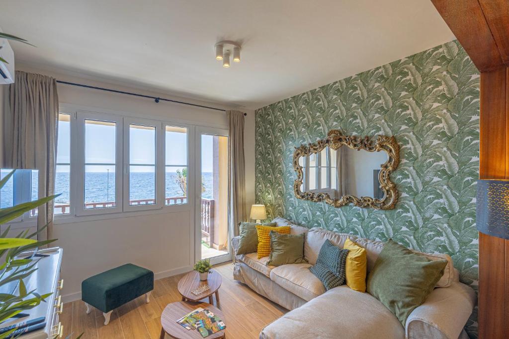 Una sala de estar con un sofá y un espejo. en El Mirador de Julia, en Santa Cruz de la Palma