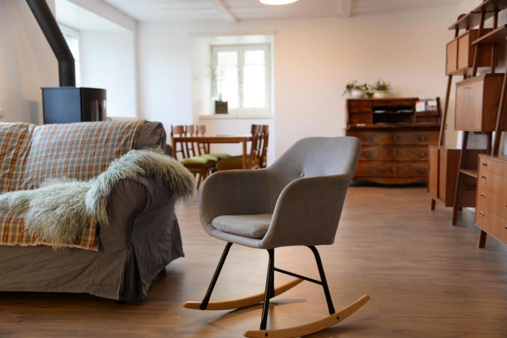 a living room with a chair and a couch at Appartement Jolimont 21 de 120m2 in Le Locle