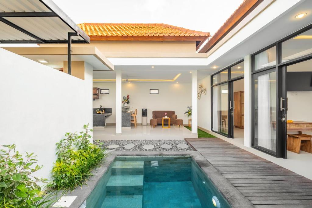 une piscine intérieure dans une villa avec une maison dans l'établissement The Lavana Bliss One Villa Nyanyi Beach, à Canggu