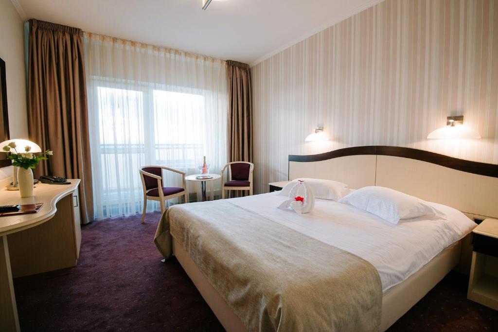 Postel nebo postele na pokoji v ubytování Caprioara Spa&Wellness Resort