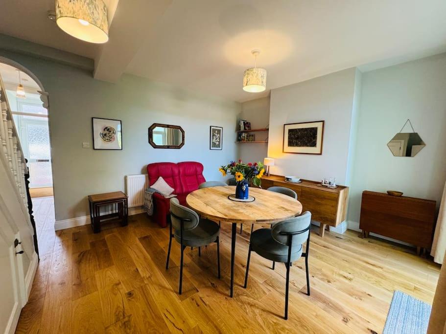 a living room with a table and chairs and a couch at Totterdown House with Views & Garden in Bristol