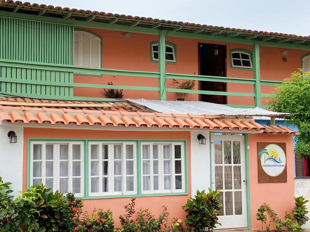 uma casa laranja e verde com janelas brancas em Pousada Hospedagem Caribe em Arraial do Cabo