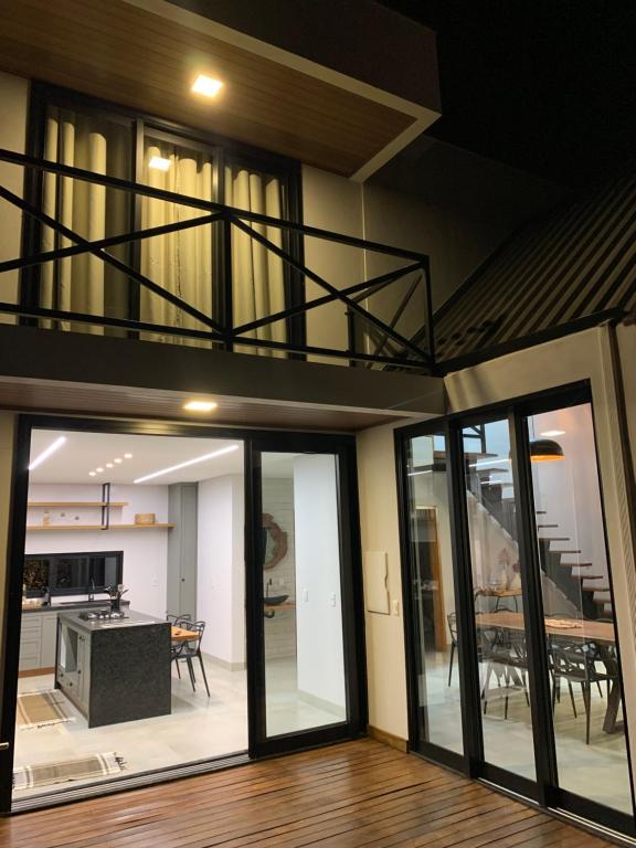 a living room with glass doors and a balcony at Chalés Piribless-Ikigai in Pirenópolis