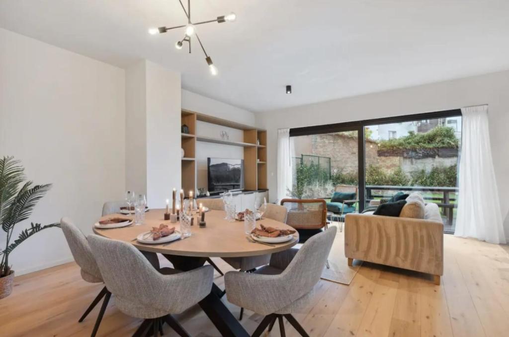 ein Esszimmer und ein Wohnzimmer mit Tisch und Stühlen in der Unterkunft Triton luxe gelijkvloers appartement met tuin en gratis garage in Knokke-Heist