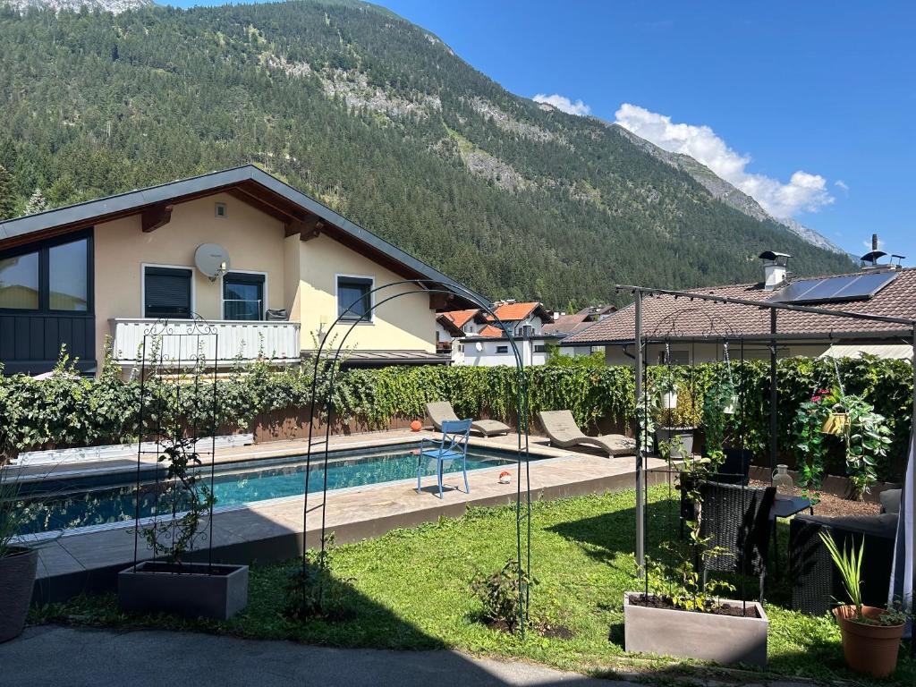 a house with a swimming pool in front of a mountain at Wellness Apartment Ilse - Apartment mit eigenem Spa in Thaur