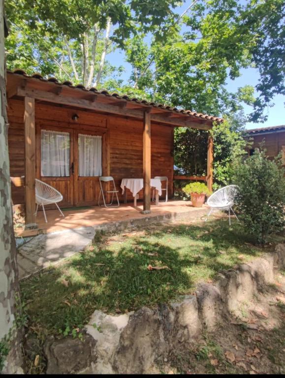 a cabin with a table and chairs in a yard at Camping La Vall d'Hostoles in Sant Feliu de Pallerols