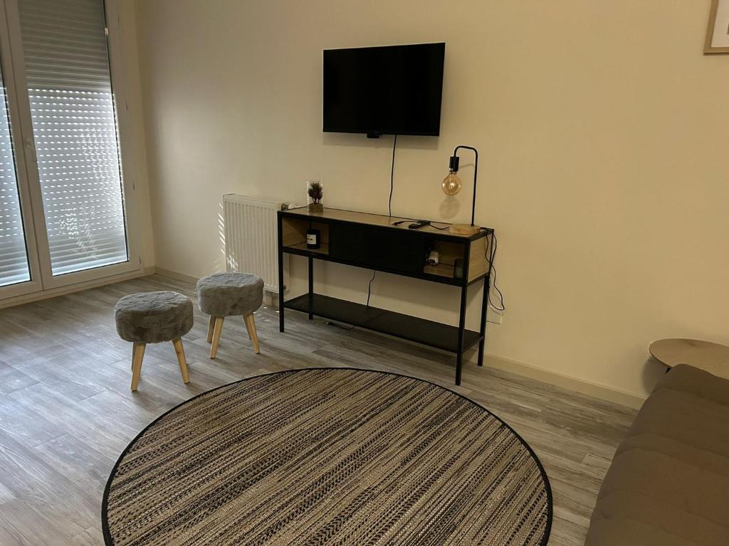 un salon avec une télévision et une table dans l'établissement Studio cosy proche Disneyland, à Ozoir-la-Ferrière