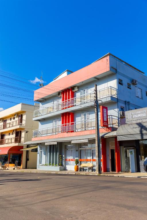 a tall building with red accents on a city street at Teuthos Hotel in Teutônia
