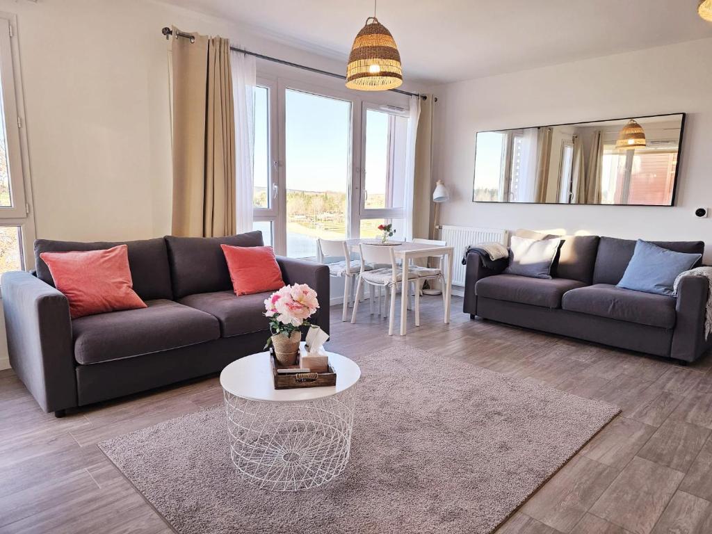 un salon avec un canapé et une table dans l'établissement Lakeside Provence - Appartement classé 4 étoiles, Vue sur le lac, Parking sous-sol, double clim, à Monteux