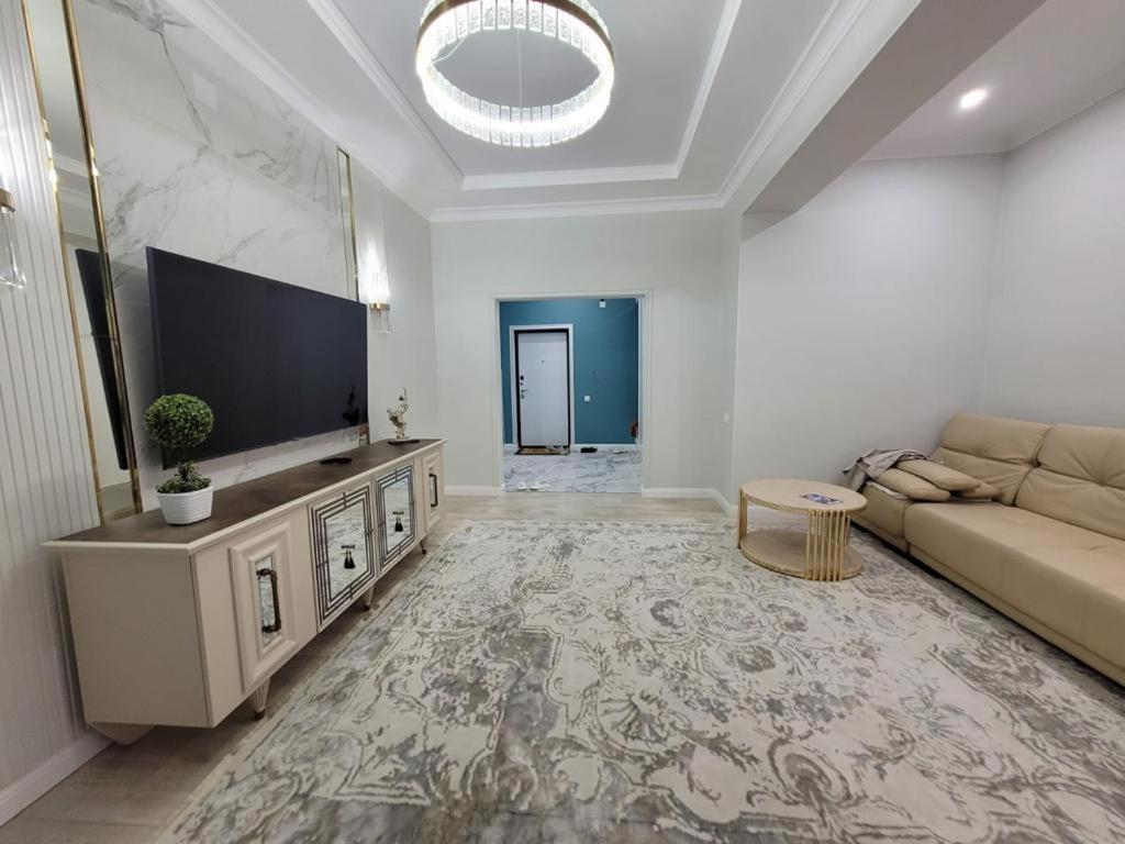 a living room with a couch and a flat screen tv at квартира in Aktau