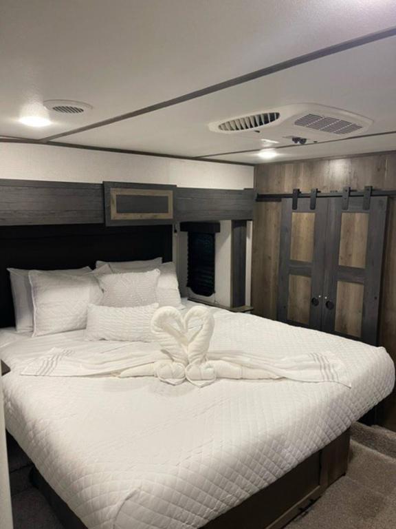 a large white bed with a white bow on it at Downtown Dade City Glamper in Dade City