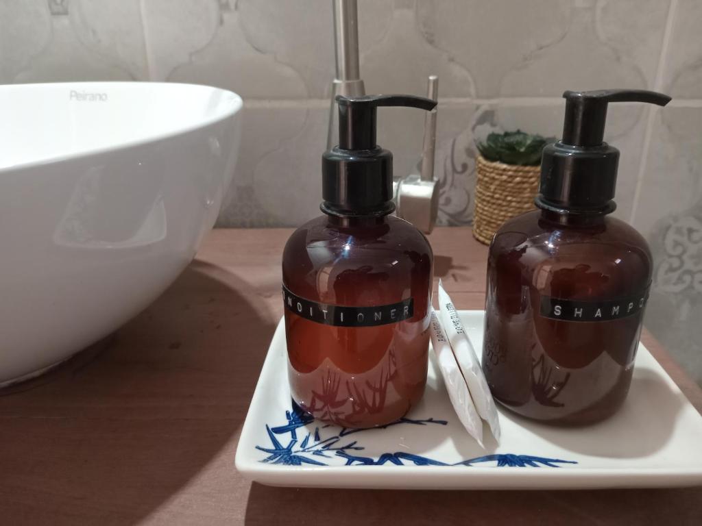 zwei Flaschen Seife auf einem Teller auf einer Theke in der Unterkunft El Olivo in Chacras de Coria