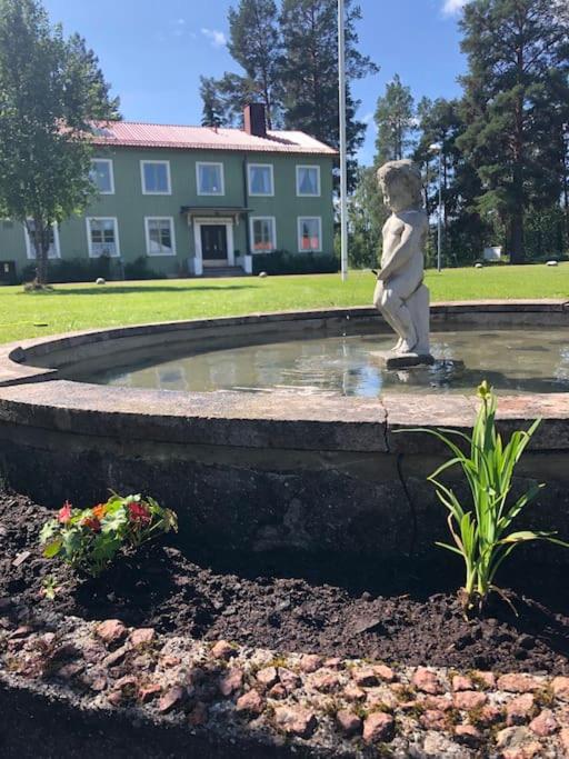 a statue of a boy walking around a fountain at Holmstagården in Bispgården