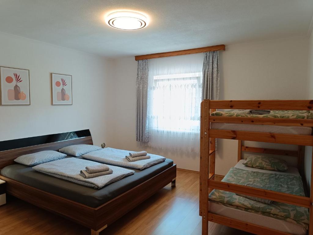 una camera con 2 letti a castello e una finestra di Ella Ferienwohnung ad Arnoldstein