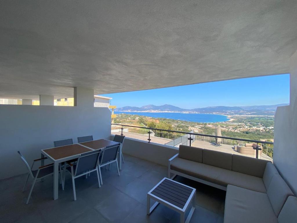 - une vue depuis le balcon d'une maison avec une table et des chaises dans l'établissement Appartement Vue Mer PORTICCIO, à Porticcio