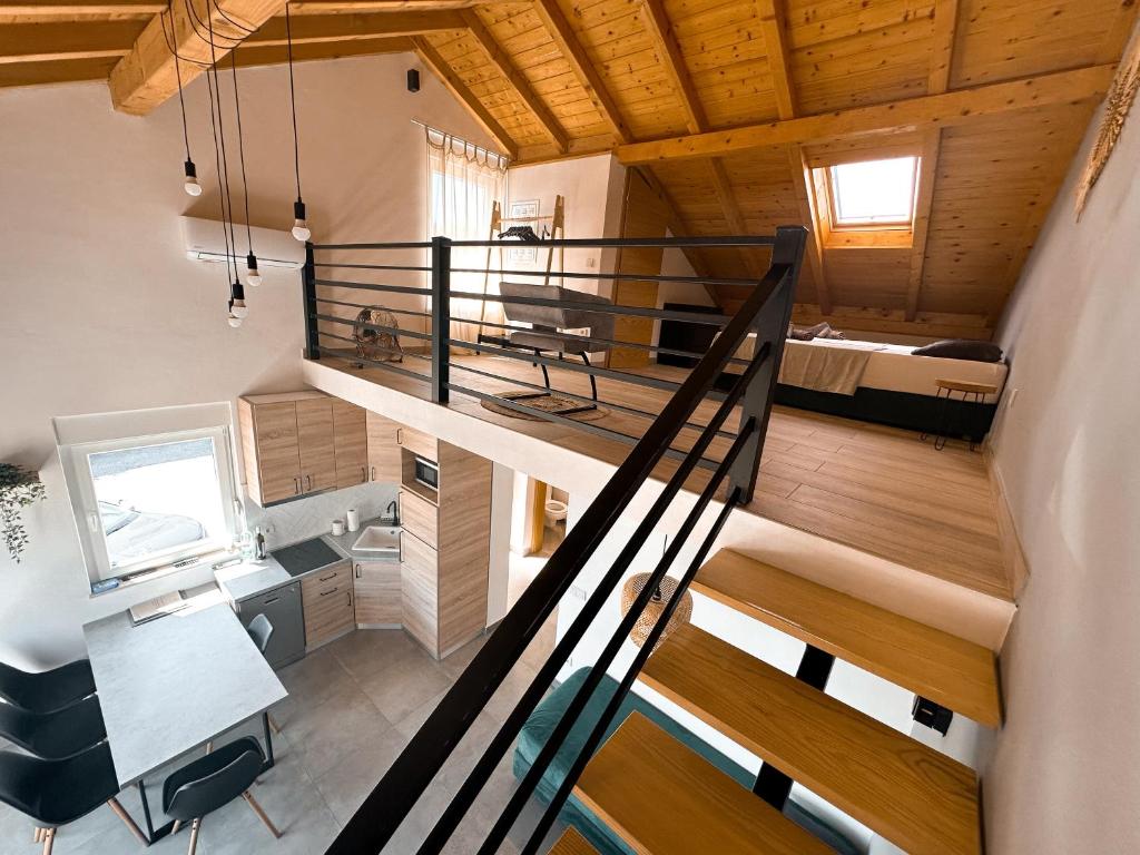 a room with a staircase leading up to a loft at Apartment house GAIA in Gajac