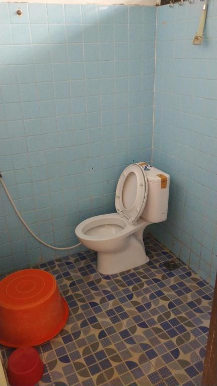 Habitación con suelo de baldosa azul y baño con aseo. en Bernard's Guest Houses, en Tuk Tuk