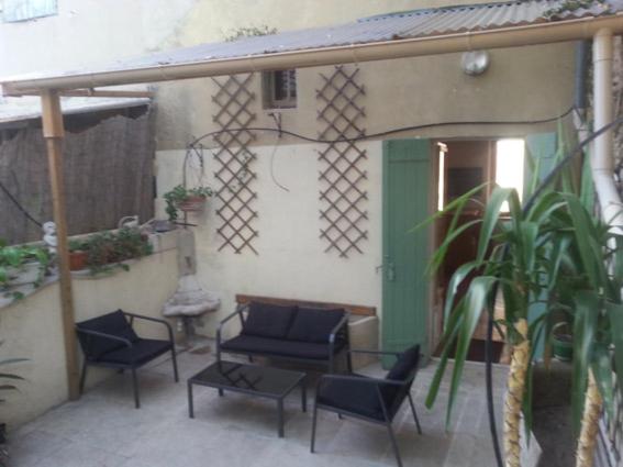 un patio avec des chaises et une table et un bâtiment dans l'établissement T4 Centre ville Orange Terrasses, à Orange