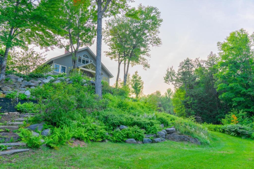 ein Haus auf einem Hügel mit Garten in der Unterkunft Dragonwood Main House in Abbot Village