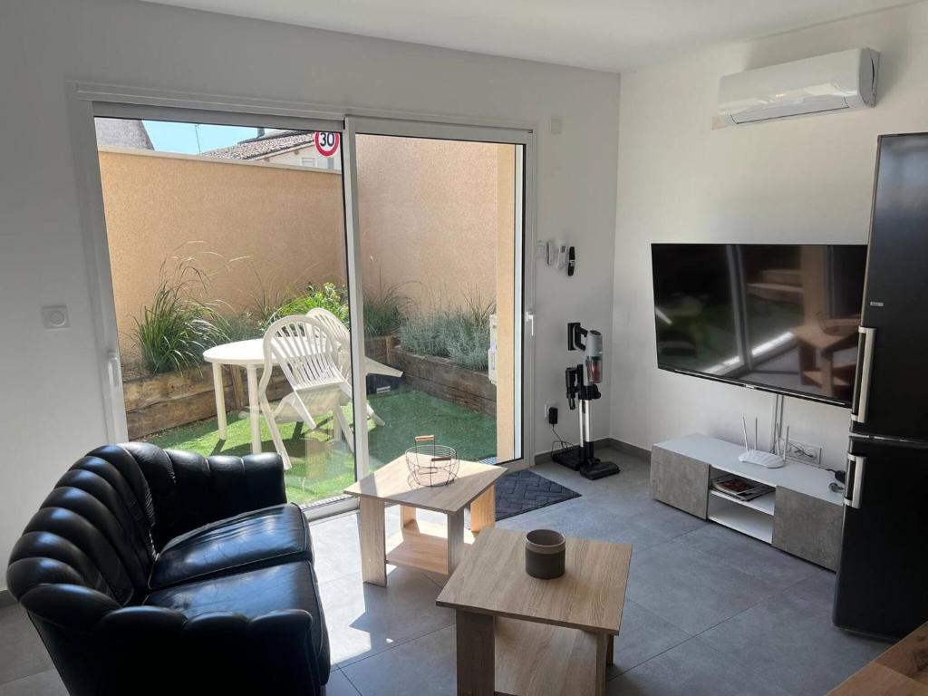 un salon avec un canapé, une télévision et une table dans l'établissement House 10 with 1 bedroom lechaffardcom, à Satolas-et-Bonce