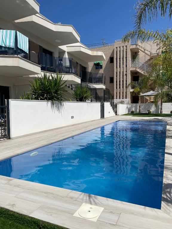 a swimming pool in front of a building at Air-conditioned Elisa Apartment with spacious sunroof lounge and swimming pool in San Javier