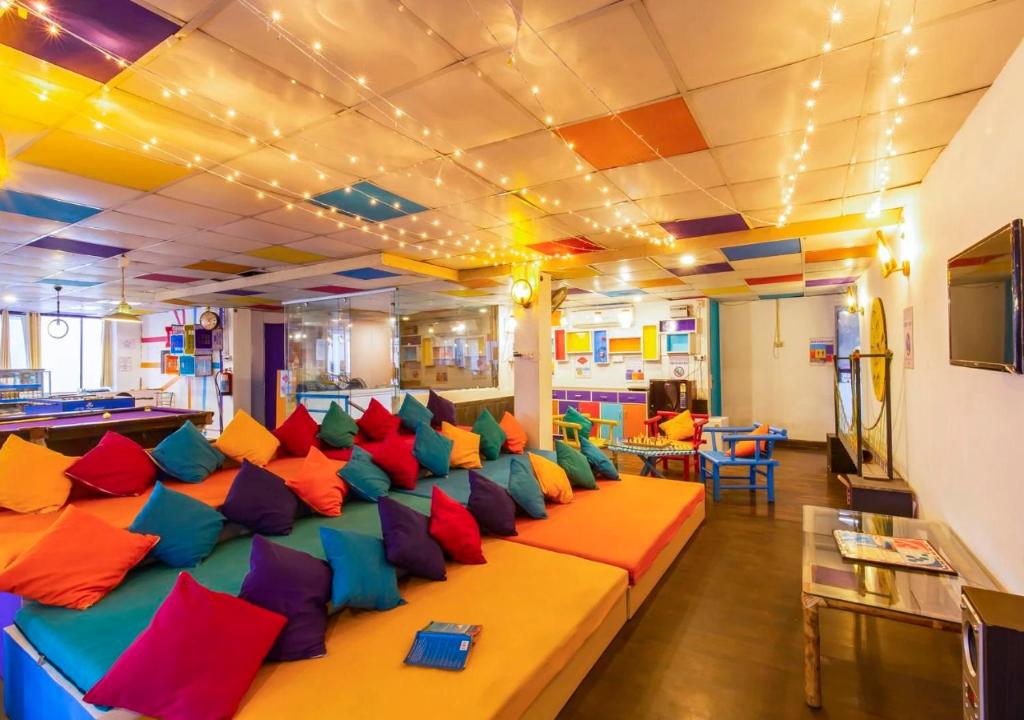 a room with a long couch with colorful pillows at ZoukStayz in Rishīkesh