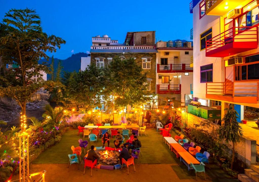 a group of people sitting at tables in a courtyard at ZoukStayz in Rishīkesh