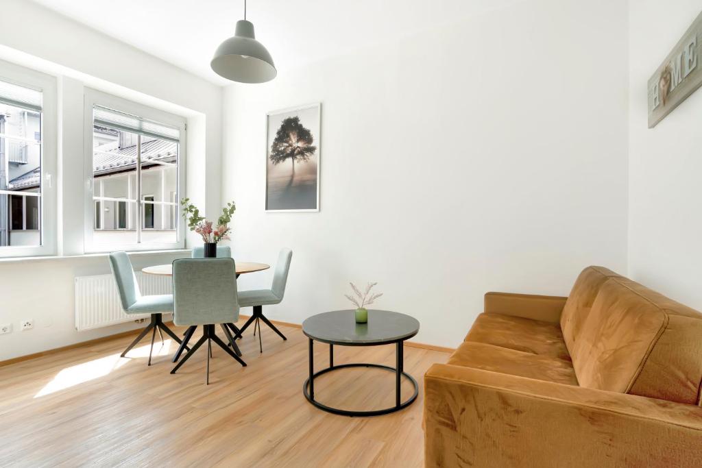 un soggiorno con un divano e un tavolo di easy flat Villach main plaza a Villach