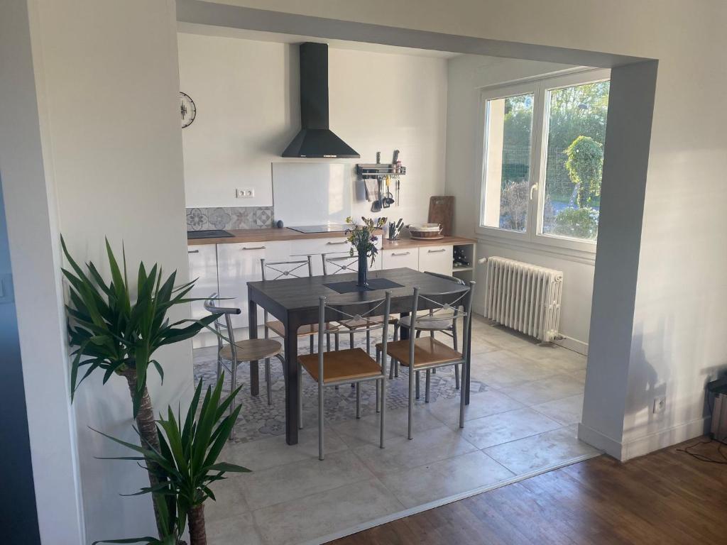 - une cuisine avec une table et des chaises noires dans la chambre dans l'établissement Du jouet, à La Roche-Derrien