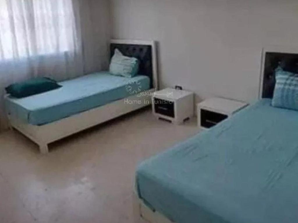 1 Schlafzimmer mit 2 Betten und 2 Tischen in der Unterkunft location saisonniere S2 a corniche in Kasnadar