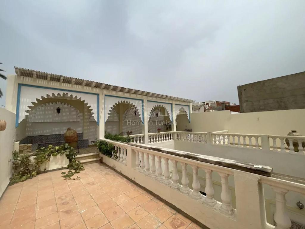 balcón de un edificio con barandilla blanca en location saisonniere Maison Traditionnelle a Monastir Medina, en Monastir
