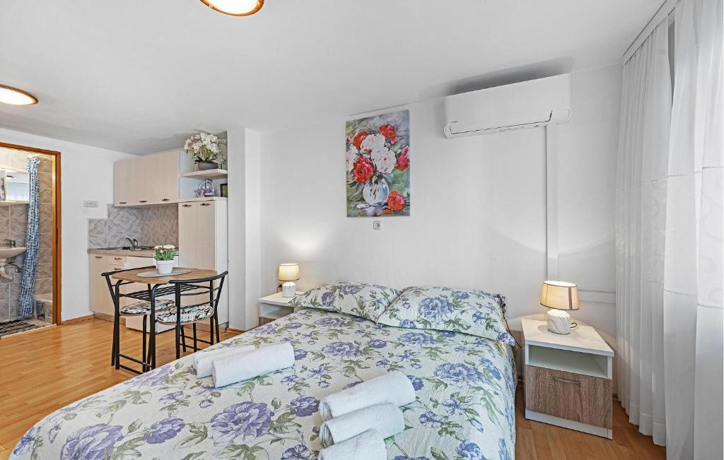 a bedroom with a bed and a table and a kitchen at Amazing Apartment In Vodice in Vodice