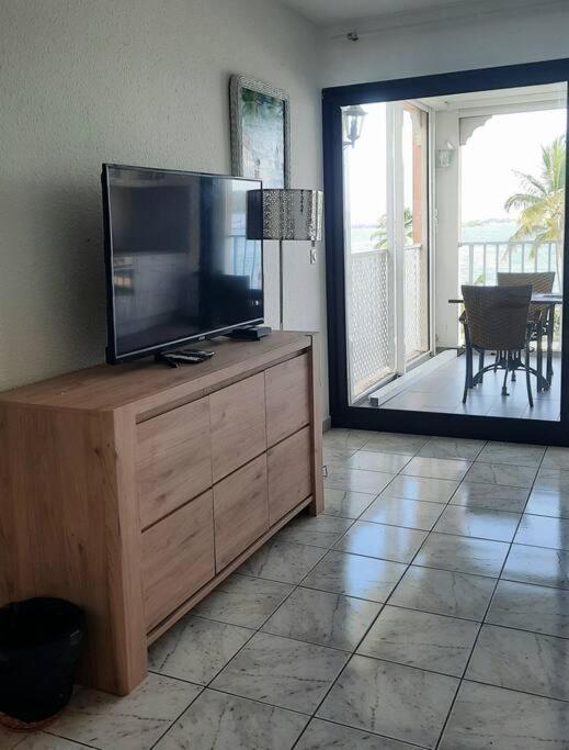 TV a/nebo společenská místnost v ubytování Studio avec piscine et vue lagon