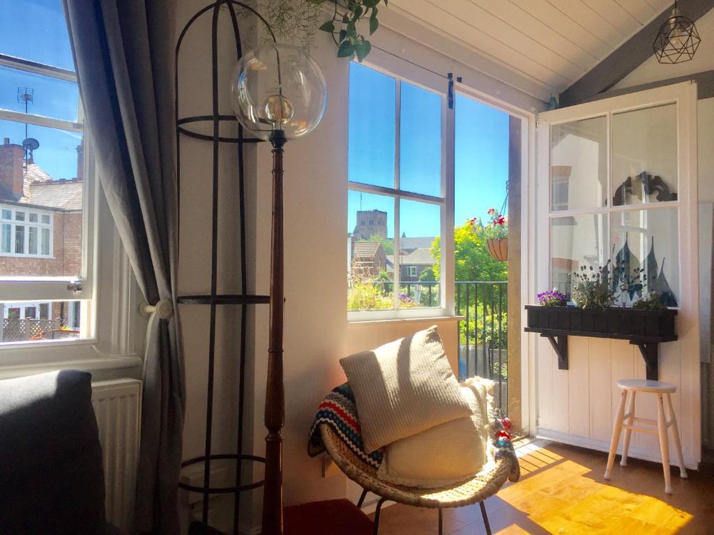 a room with a chair and a lamp and a window at Beautiful City Centre Apartment with Cathedral View in St. Albans