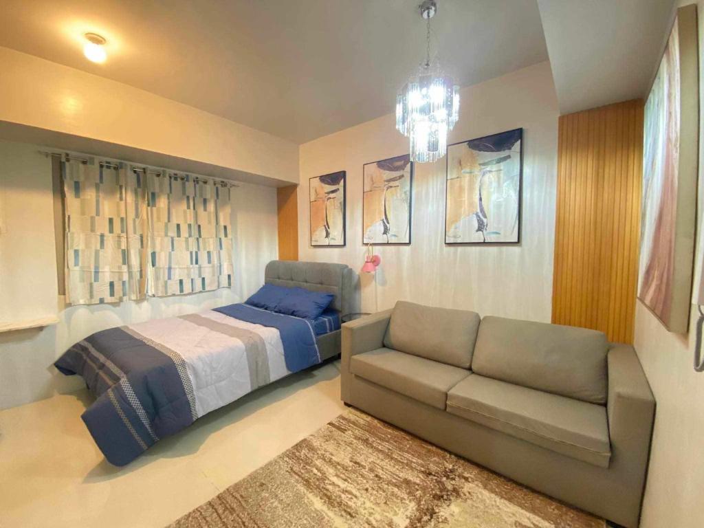 a bedroom with a bed and a couch at Studio Condo near Ayala, Cebu-East Gate in Carreta