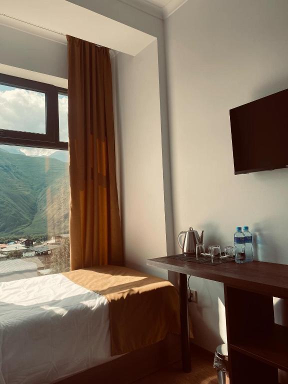 Postel nebo postele na pokoji v ubytování Melodia KAZBEGI