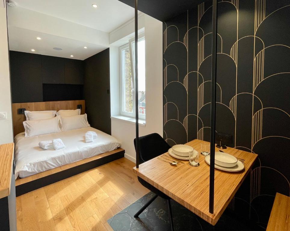 une chambre avec un lit et une table en bois dans l'établissement Le Eight - Villa la Potinière - Moderne & Intime - Front de mer, à Dunkerque