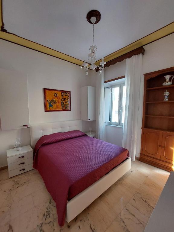 a bedroom with a purple bed and a window at Palazzo Sardanelli in Pizzo