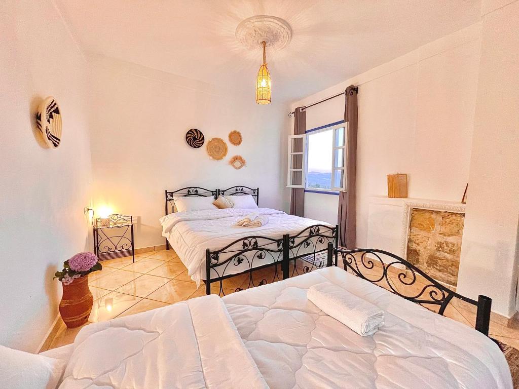 a bedroom with two beds and a window at Dar Bakkali Nadi in Tangier