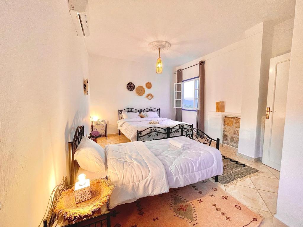 a bedroom with two beds and a window at Dar Bakkali Nadi in Tangier