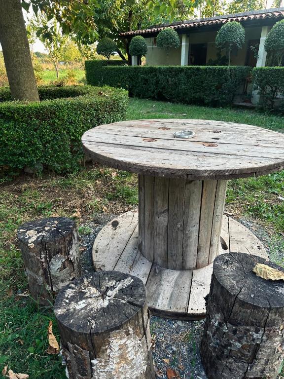 un tavolo di legno con tre tronchi intorno di Xhani Camping&Farm a Gucia e Re