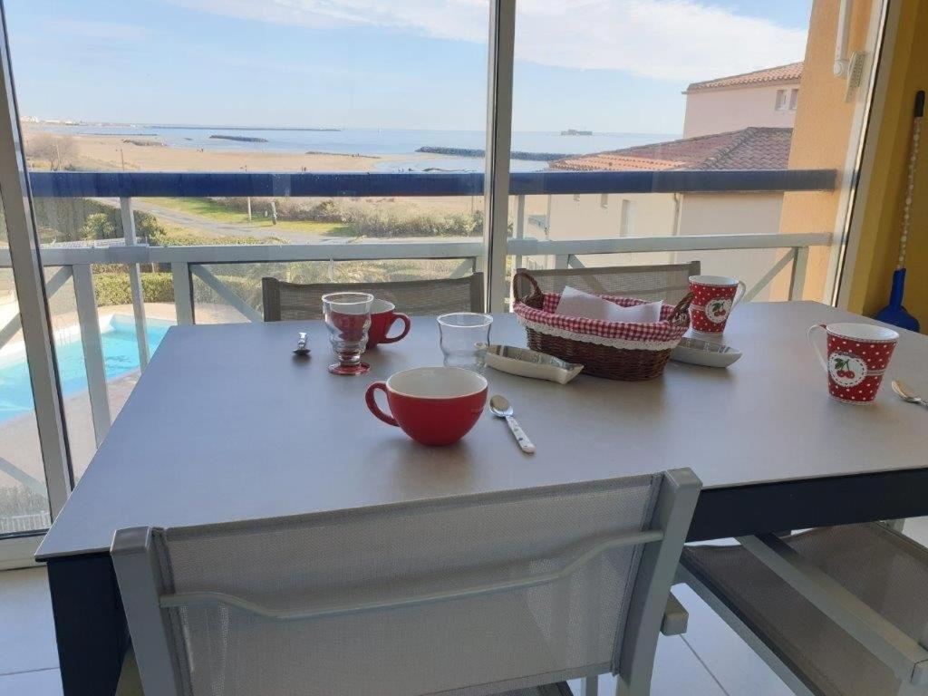 d'une table et d'une chaise avec vue sur l'océan. dans l'établissement SAVANNA BEACH I Joli T2 vue mer piscine Cap d'Agde, au Cap d'Agde