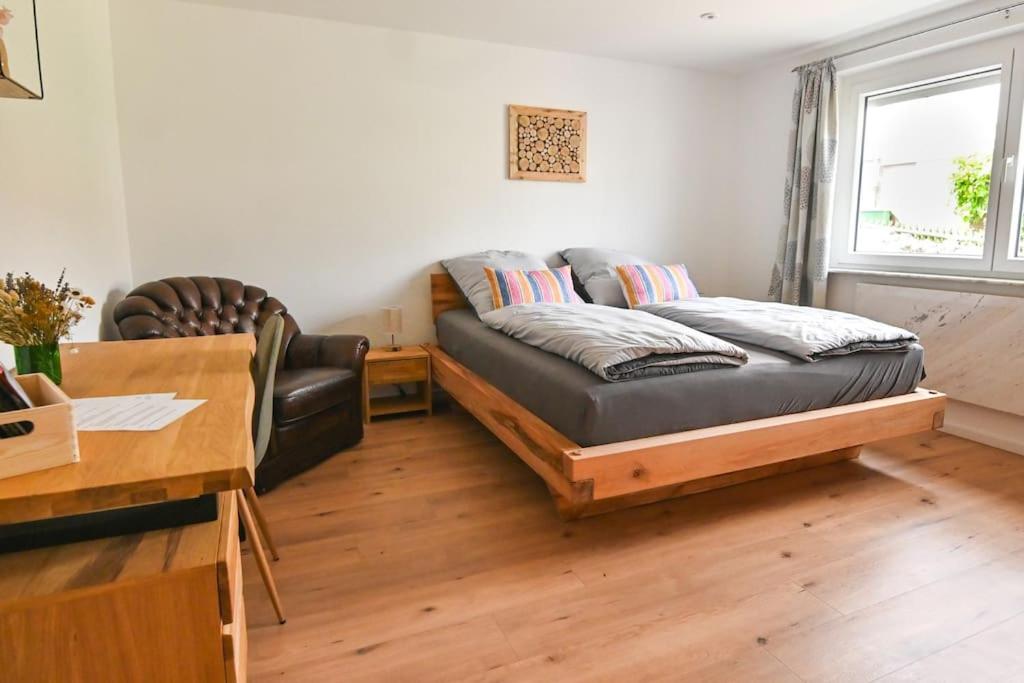 a living room with a couch and a desk at Entspannung und Erholung, Ferienwohnung mit traumhaftem Blick in die Natur in Oberaurach