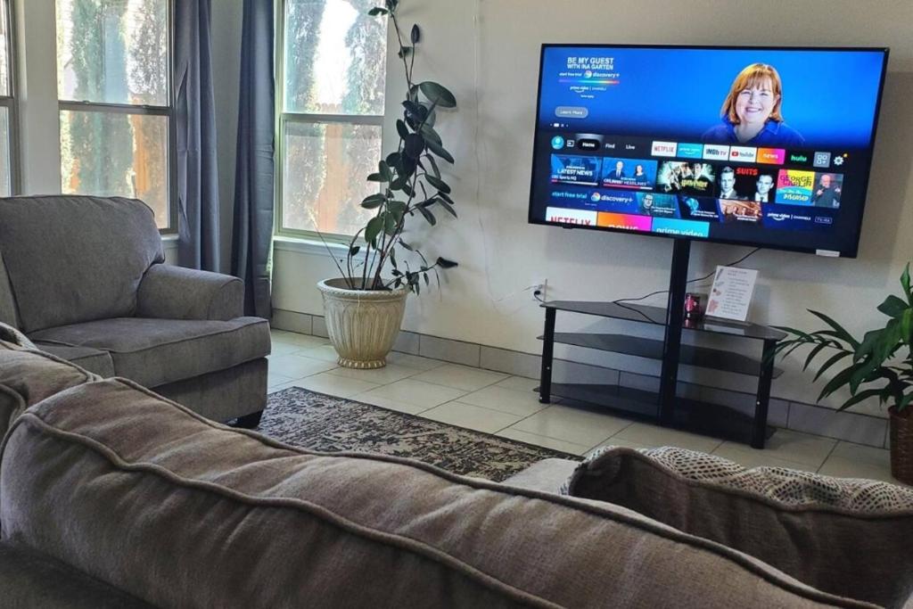 a living room with a couch and a flat screen tv at Lovely Room 1 Near San Marcosatx in Kyle